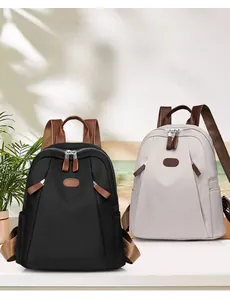 Front view of black and beige nylon backpacks with leather accents and colorblock straps