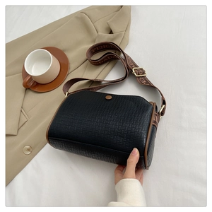 Detailed view of black woven texture leather bag with PENGDADA strap and brown trim