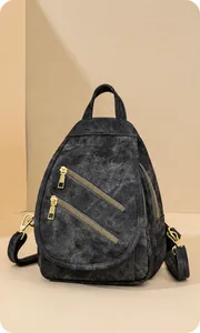 Detalle del bolso bandolera vintage gris oscuro con cremalleras doradas y textura suave
