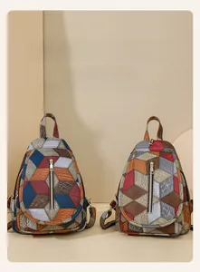 Dettaglio della texture patchwork in pelle geometrica e cerniere metalliche dello zaino