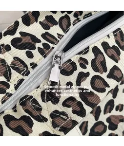 Close-up of a leopard print canvas tote bag featuring a polished silver metal zipper pull