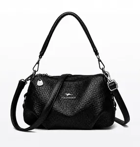 Vue de face du sac bandoulière noir avec logo kangourou doré et texture grainée