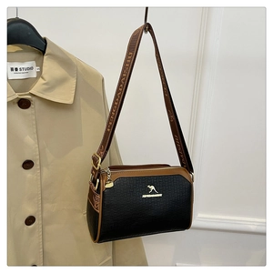 Detailed close-up of a black textured crossbody bag featuring a golden kangaroo logo