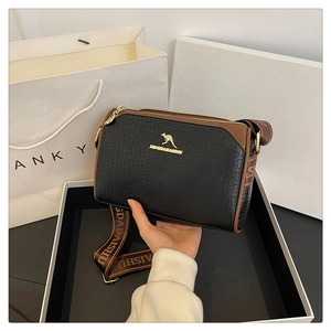 Detail of black embossed leather Boston bag with gold kangaroo logo and wide strap