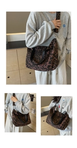 Detail of leopard print canvas tote bag featuring leather handles and adjustable shoulder strap