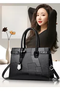 Detail view of large geometric patchwork tote bag with silver hardware and shoulder strap