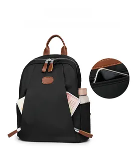 Detail view of nylon backpack showing front zipper pocket storage and side water bottle holder