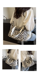 Detail of leopard print canvas tote bag featuring white leather handles and shoulder straps