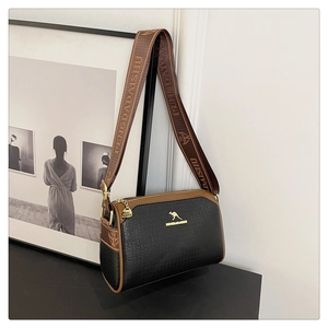 Detailed macro view of black PU leather Boston bag with gold kangaroo logo and wide strap