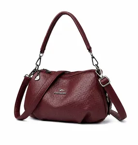 Détail du sac bandoulière bordeaux en similicuir grainé avec fermetures éclair argentées
