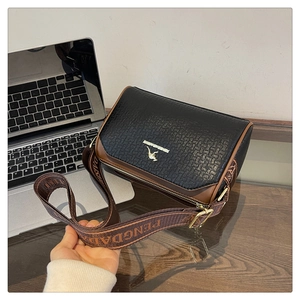 Close-up of woven texture black leather bag with gold kangaroo logo and brown trim