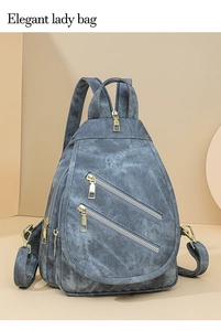 Detalle de bolso de pecho denim gris azulado con cremalleras doradas y correa ajustable