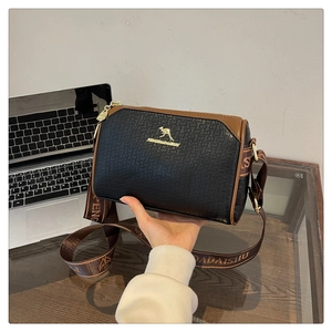 Detail of black and brown two-tone bag featuring a gold kangaroo logo and jacquard strap