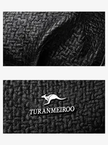 Détail de la texture cuir noir avec logo de marque argenté embossé sur le sac à main