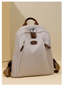 Detail of stylish nylon backpack featuring brown leather accents and dual side pockets