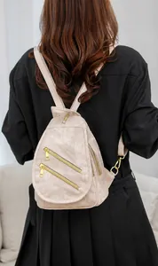 Detalle de la mochila de cuero sintético beige con tres cremalleras doradas diagonales
