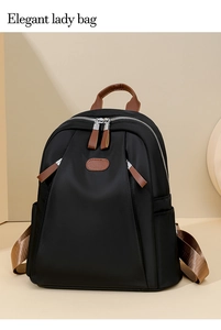 Detail of elegant black nylon backpack with brown leather accents and top handles