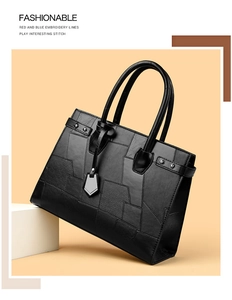 Detail of black patchwork tote bag showing rivet accents and mixed leather textures