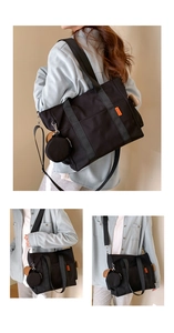 Detail of black large nylon tote bag featuring orange letter patch and small round pouch