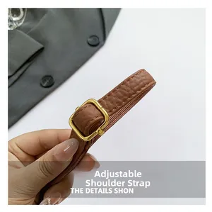 Detail of adjustable dark brown PU leather shoulder strap with gold metal buckle