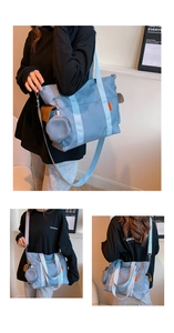 Detail of light blue nylon tote bag showing round coin purse and orange logo tag