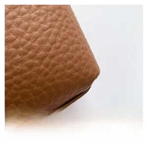 Close-up of caramel brown bucket bag showing premium lychee grain leather texture