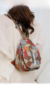 Dettaglio dello zaino patchwork geometrico colorato con design multitasche e zip in metallo
