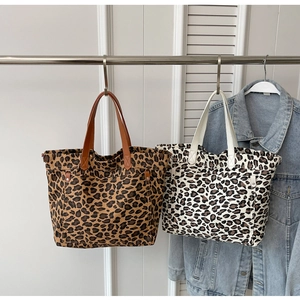 Detail of leopard print canvas tote bags with reinforced handles and sturdy bottom stitching