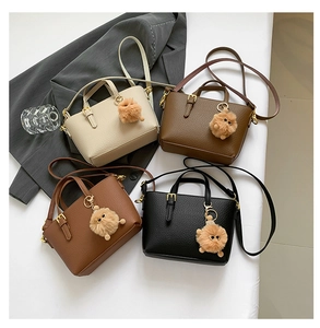 Detail view of four textured bucket bags in various colors with cute bear charms