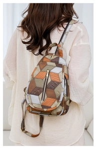 Dettaglio di un mini zaino patchwork geometrico con spallacci regolabili su una modella