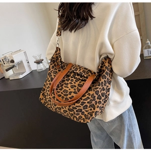 Leopard print tote bag with brown leather straps shown in a cross-body style view