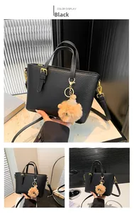 Detail of black lychee grain leather bucket bag with gold hardware and plush charm