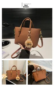 Detailed view of reddish-brown litchi pattern bucket bag with plush charm and gold hardware