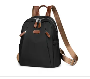 Side view of black nylon backpack with brown leather straps and silver metal hardware
