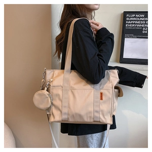 Detail of beige nylon tote bag with adjustable strap and detachable mini coin purse