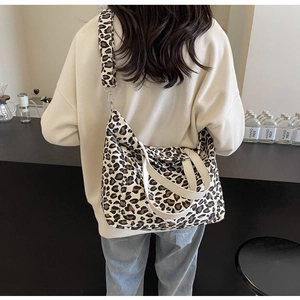 Rear view of a large leopard print canvas tote bag styled with casual outfit in a cafe