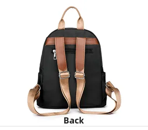Detail of black nylon backpack back with brown leather handles and hidden zipper pocket