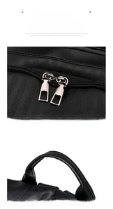Detail of matte metal zippers and vertical stripe texture on a black nylon backpack