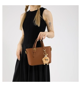 Brown litchi grain bucket bag with gold hardware and a cute plush doll keychain