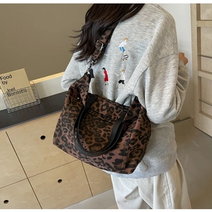 Rear view of a stylish leopard print tote bag with black handles and wide shoulder strap