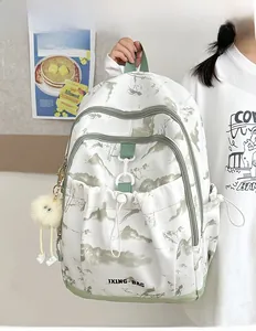 Détail du sac à dos avec imprimé paysage floral, poche à cordon et pompon en peluche
