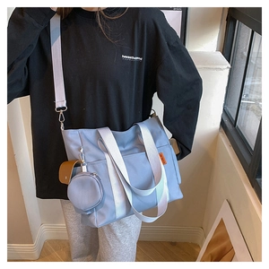 Close-up of grey-blue nylon tote bag with round coin purse and wide shoulder strap