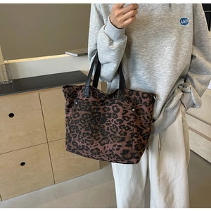 Detail of leopard print tote bag with large front pocket and durable handles
