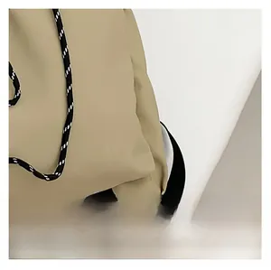 Detail of khaki waterproof nylon fabric with decorative black and white drawstring cord