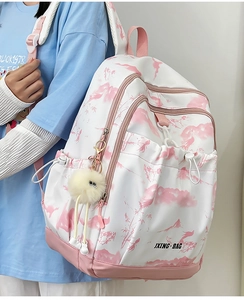 Vue latérale du sac à dos tie-dye blanc et rose avec pendentif peluche sur mannequin