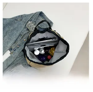 Detail showing high capacity of khaki nylon drawstring backpack with laptop and accessories
