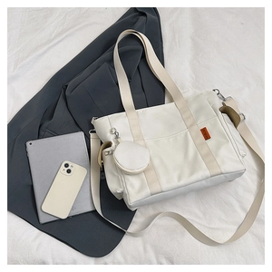 Detail of a large nylon tote bag with a matching round coin purse and adjustable strap
