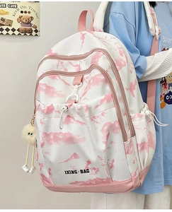 Détail du sac à dos imprimé floral rose avec logo JXING BAG et porte-clé peluche œil