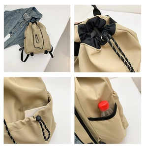 Detail of khaki nylon backpack with drawstring closure and functional side pockets