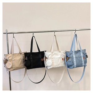 Detail view of four nylon tote bags in khaki, black, white, and blue with coin purses